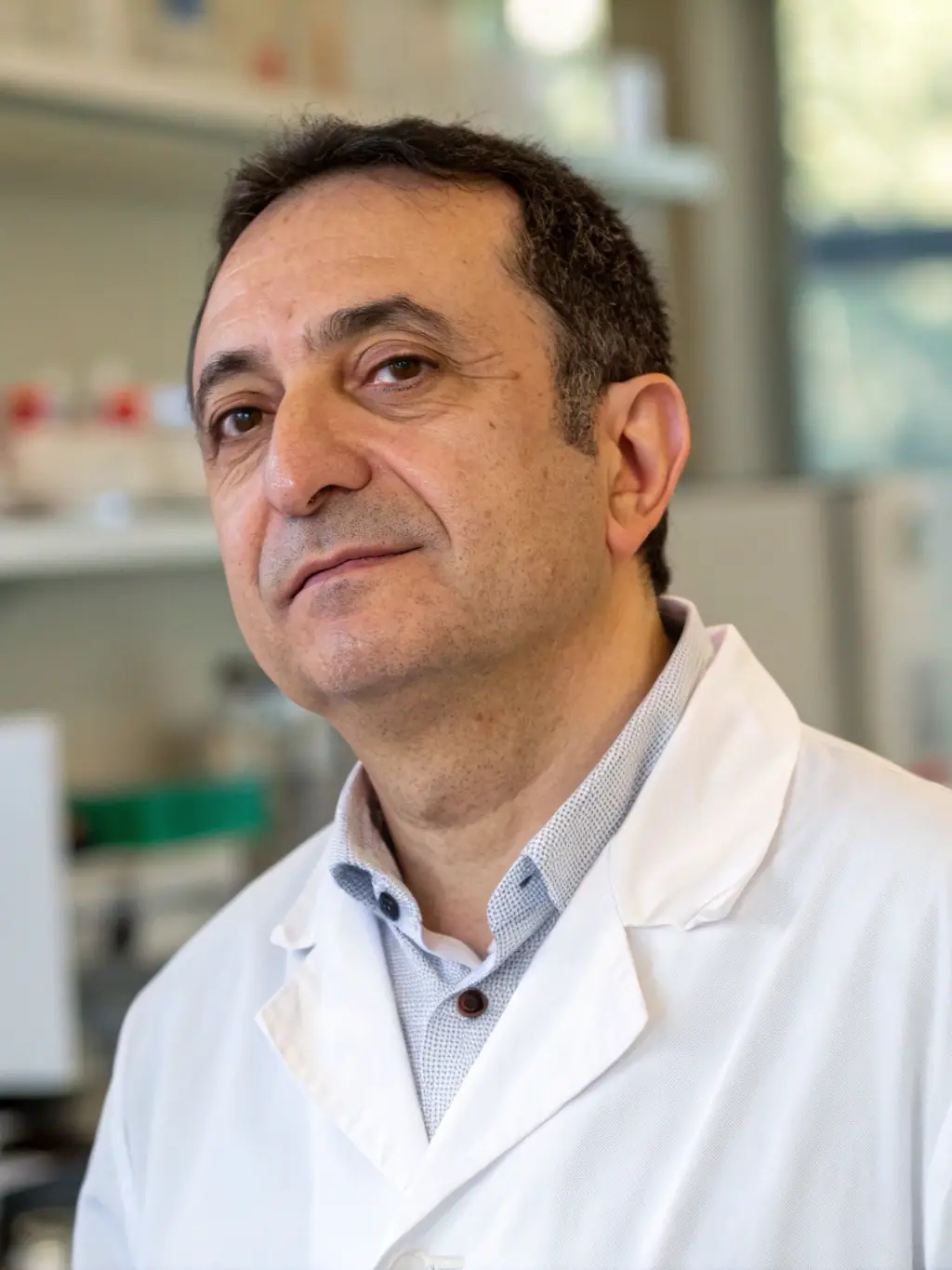 A professional headshot of Professor Marco Bianchi, an expert in nutritional genomics, looking directly at the camera. He is wearing a lab coat.